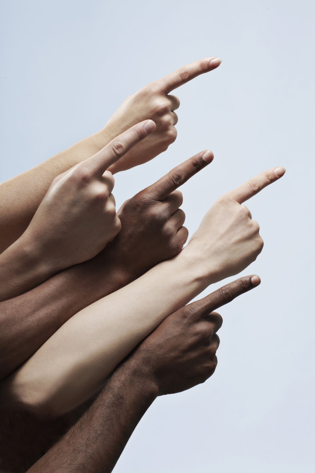 Mehrere Hände, die mit dem Zeigefinger in die gleiche Richtung zeigen.