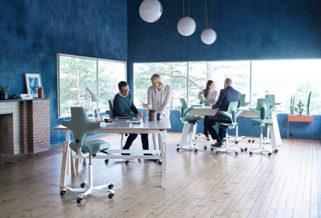 Modernes Büro mit Mitarbeitern, die in Gespräche vertieft sind.